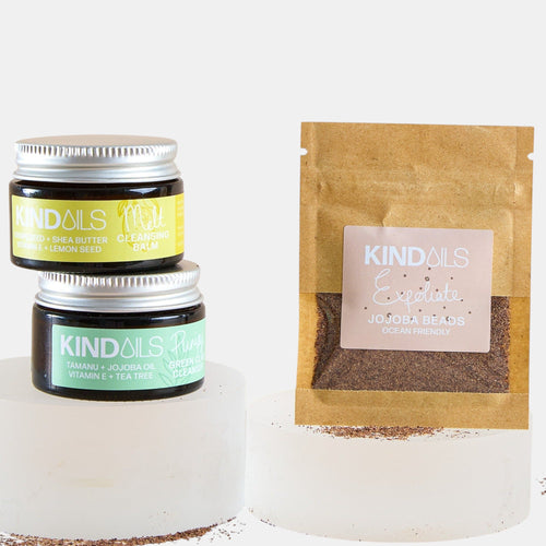 Two jars and a brown paper bag with kind oils branding on a white background.