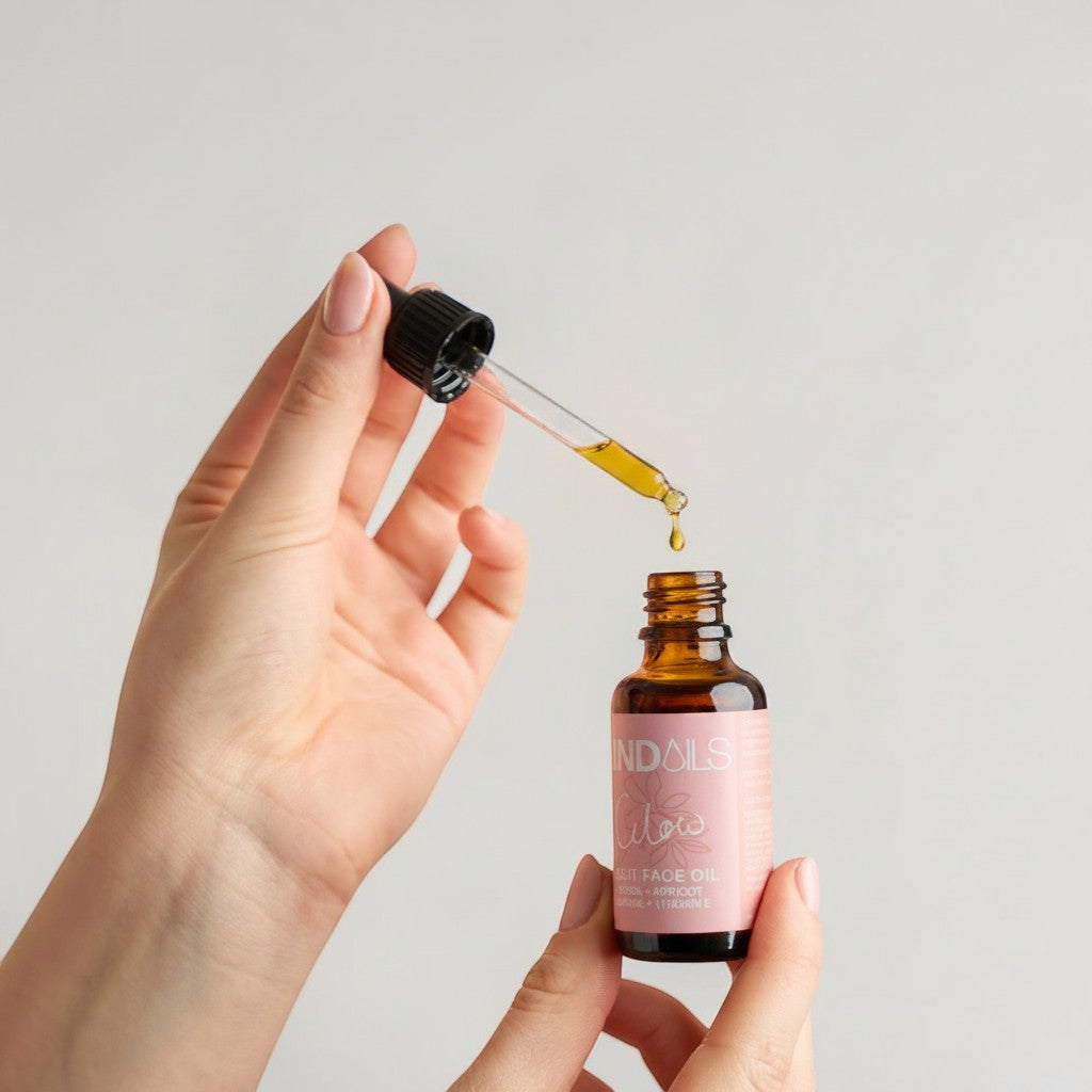 Kind Oils Glow Light Face Oil with dropper dispensing golden oil. Packed with 9 botanicals for radiant skin.